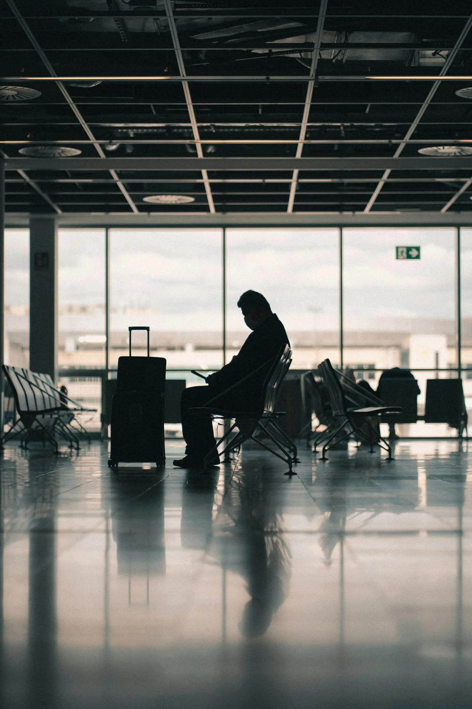 A traveller with a suitcase waiting in an airport departure lounge